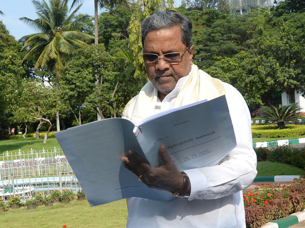 Chief Minister Siddaramaiah goes through documents on the eve of the state budget on Tuesday. DH photo