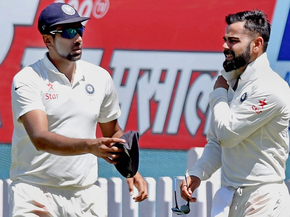 Indian skipper Virat Kohli winces after injuring himself in a fielding effort as teammate R Ashwin offers him his cap during the first day of the 3rd Test match against Australia in Ranchi on Thursday. PTI Photo