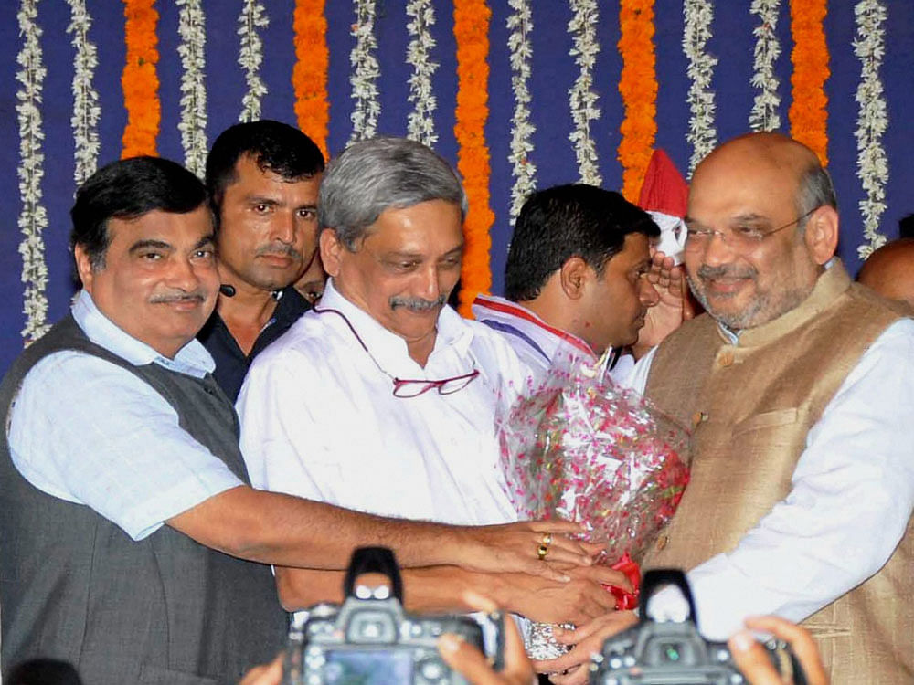Newly sworn-in Goa Chief Minister Manohar Parrikar being greeted by BJP President Amit Shah and Union minister Nitin Gadkari after his oath at a ceremony in Panaji on Tuesday. PTI Photo