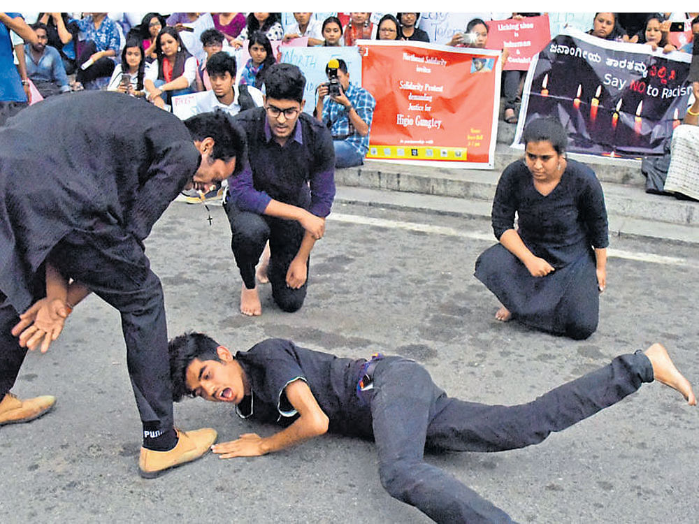 Various organisations and students of Christ College stage a street play in protest against the assault on fellow student, Higio Gungtey, outside Town Hall on Thursday. DH photo