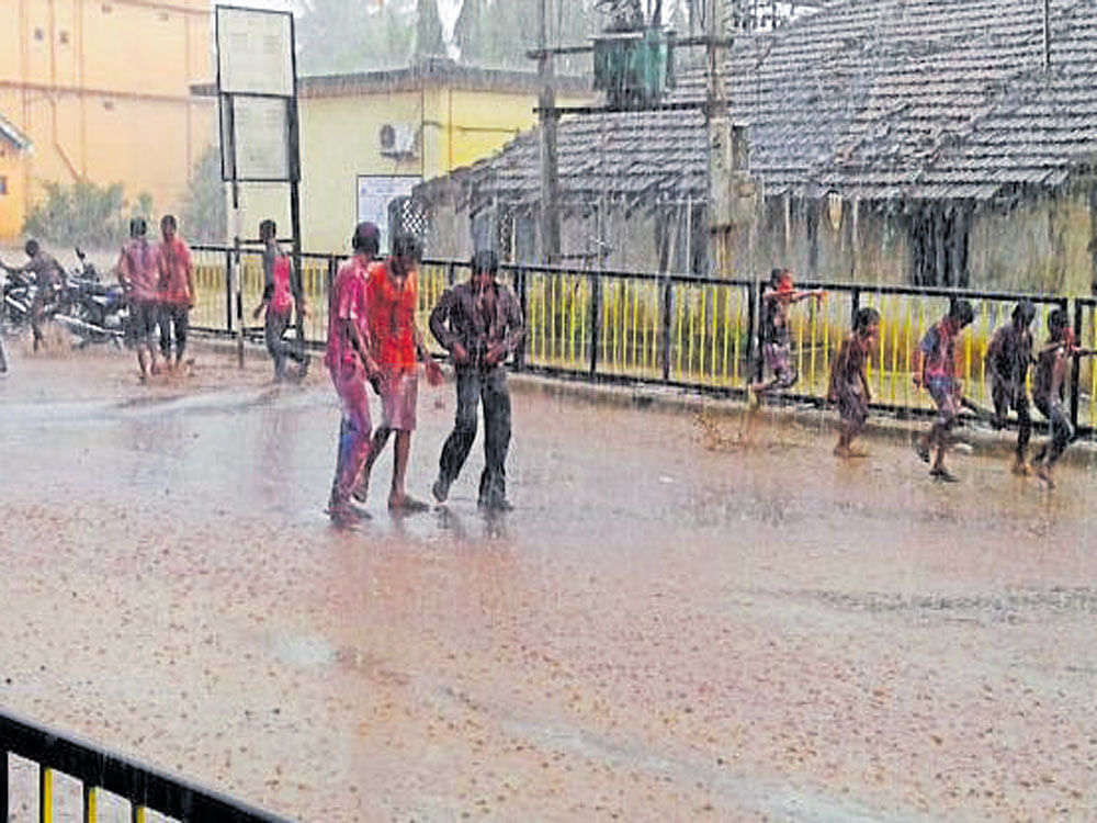 Children get wet in rain in Mundgod, Uttara Kannada district, on Thursday. DH photo