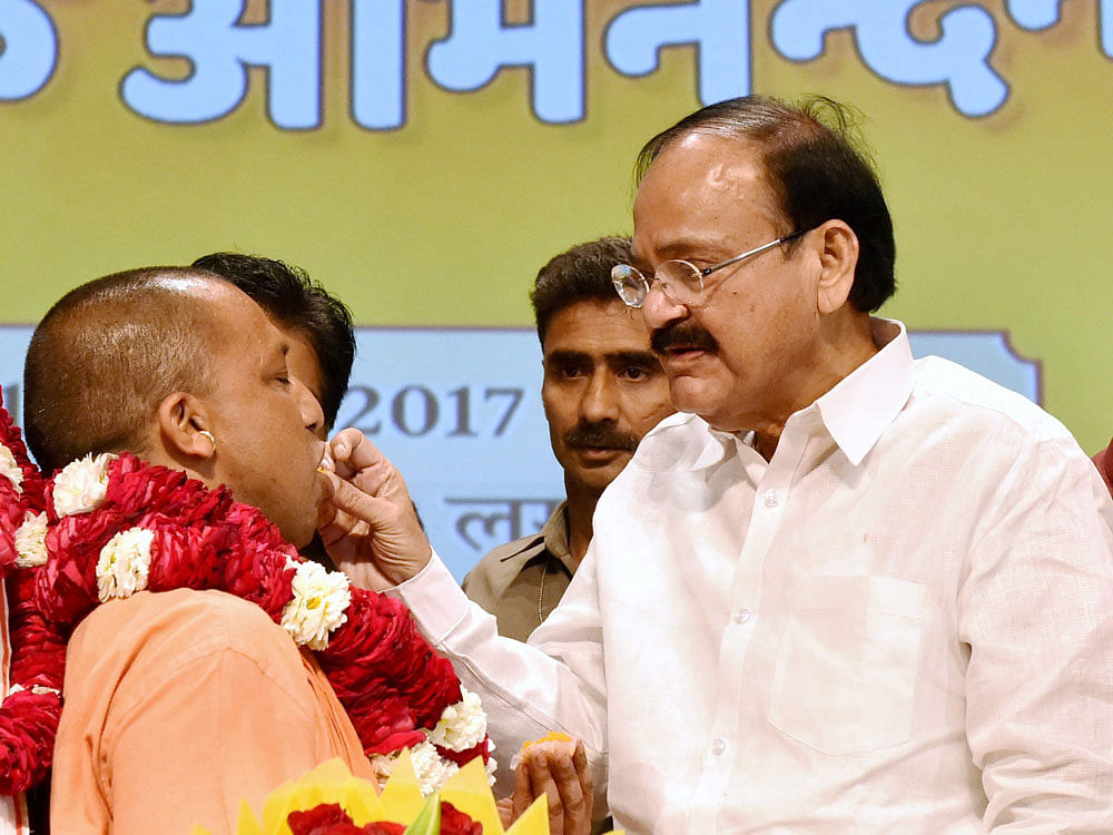 Union Minister for Information and Broadcasting M Venkaiah Naidu offering sweets to Yogi Adityanath after elected leader of the BJP Legislature Party in Lucknow on Saturday.PTI Photo