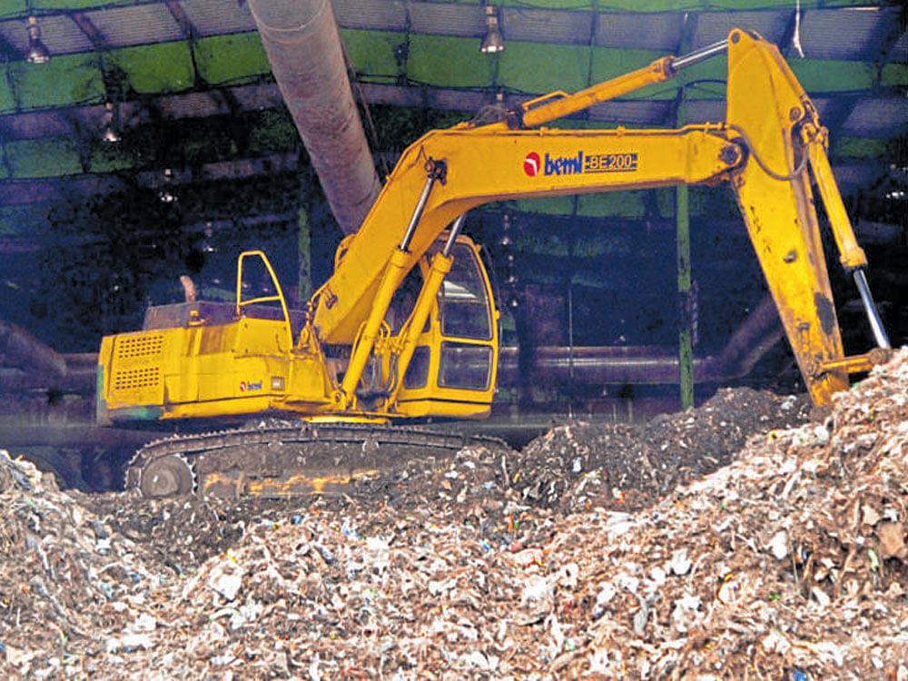 A crane levels garbage in the KCDC waste-processing unit at Somasundarapalya in Bengaluru on Monday. DH PHOTO