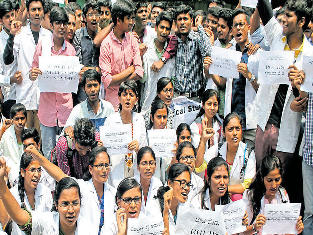 Students of medical colleges affiliated to RGUHS protest at Mysore Bank Circle against the move to shift the university headquarters from Jayanagar to Ramanagaram on Tuesday. DH photo