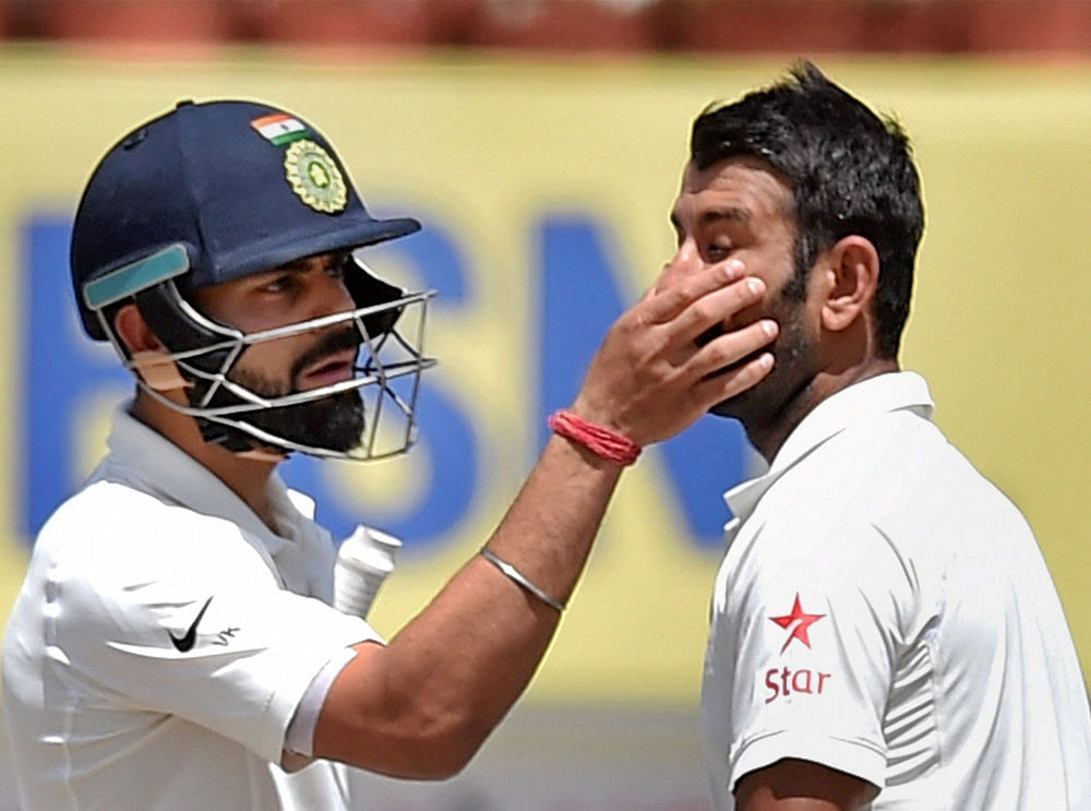 Indian Captain Virat Kohli removing dust from eye of his teammate C Pujara during 3rd day of 3rd Test Match against Australia in Ranchi on Saturday. PTI file Photo
