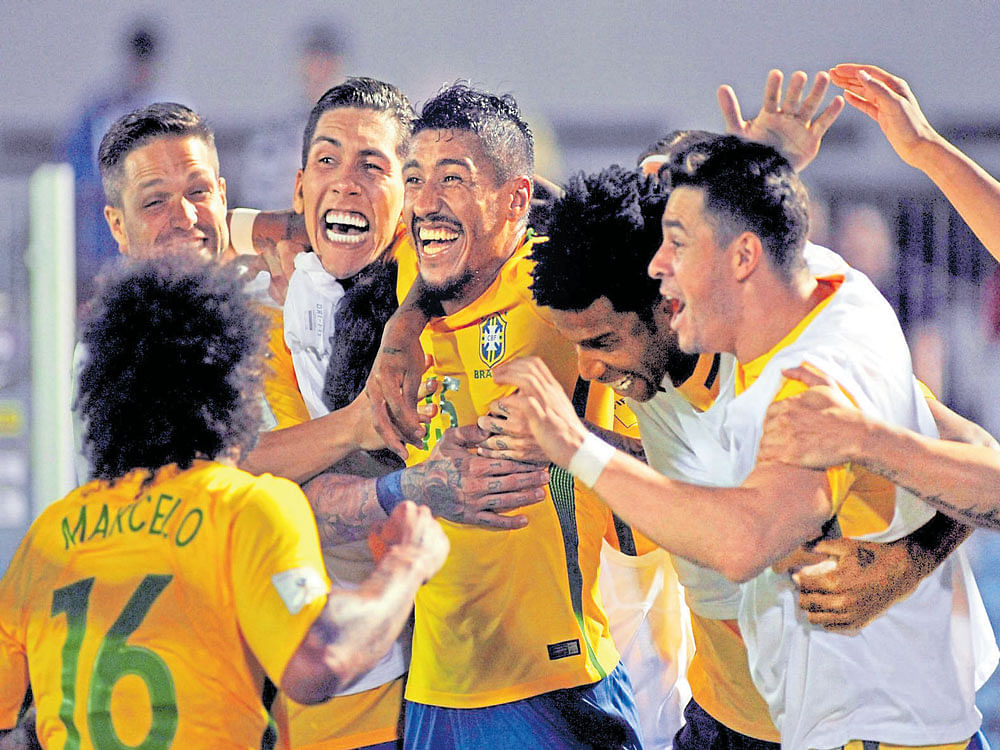 man of the moment: Brazil's Paulinho (centre) celebrates with team-mates after scoring against Uruguay in Montevideo. AFP