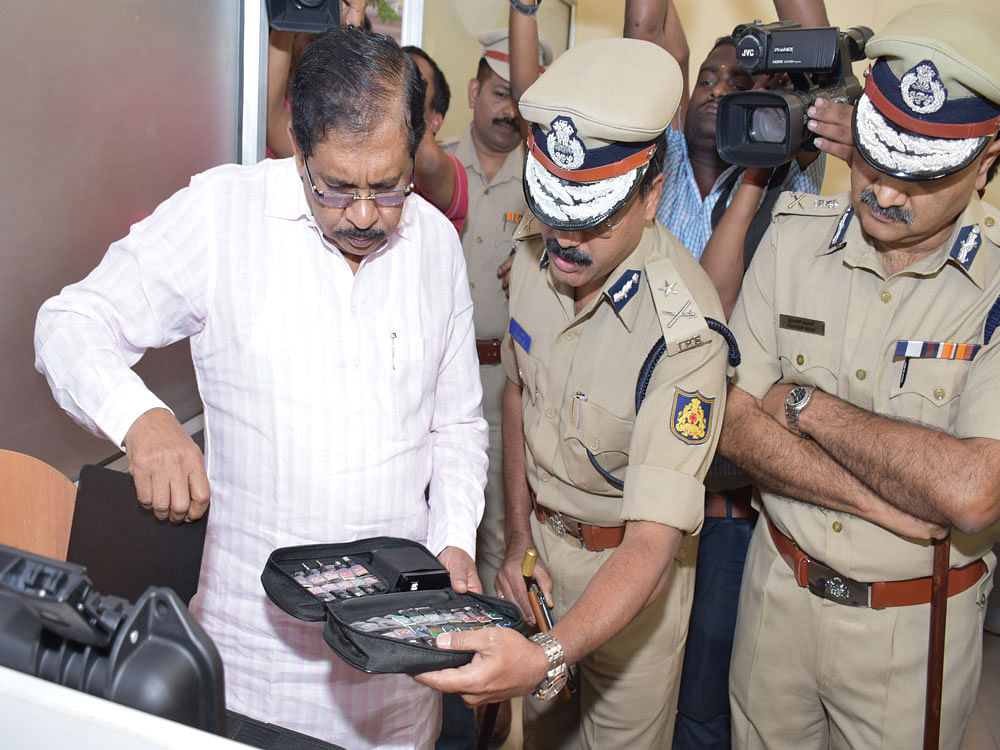 Home Minister G Parameshwara looking equipment after Cyber Crime Police station inauguration in Bengaluru on Saturday. Ravi S, Additional Commissioner of Police (crime) and Praveen Sood, Police Commissioner are seen. DH photo