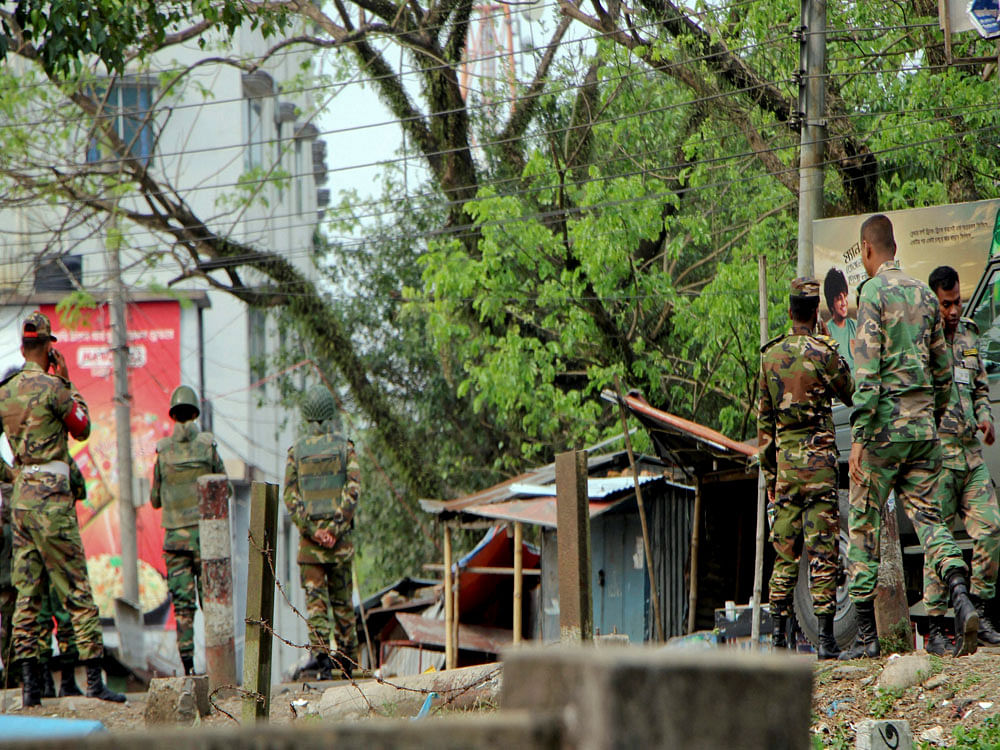 Bangladeshi troops cordon off the area as they try to flush out Islamist radicals who have holed up in a building with a large cache of ammunition in the city of Sylhet, Bangladesh, Sunday, March 26, 2017. At least six people, including two policemen, have died in explosions in eastern Bangladesh as troops battle suspected militants. AP/PTI