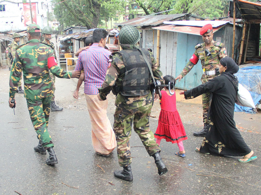 Bangladesh Army personnel escort a family after rescuing them from a militant hideout during an operation in Sylhet, Bangladesh. Picture taken March 25, 2017. REUTERS Photo