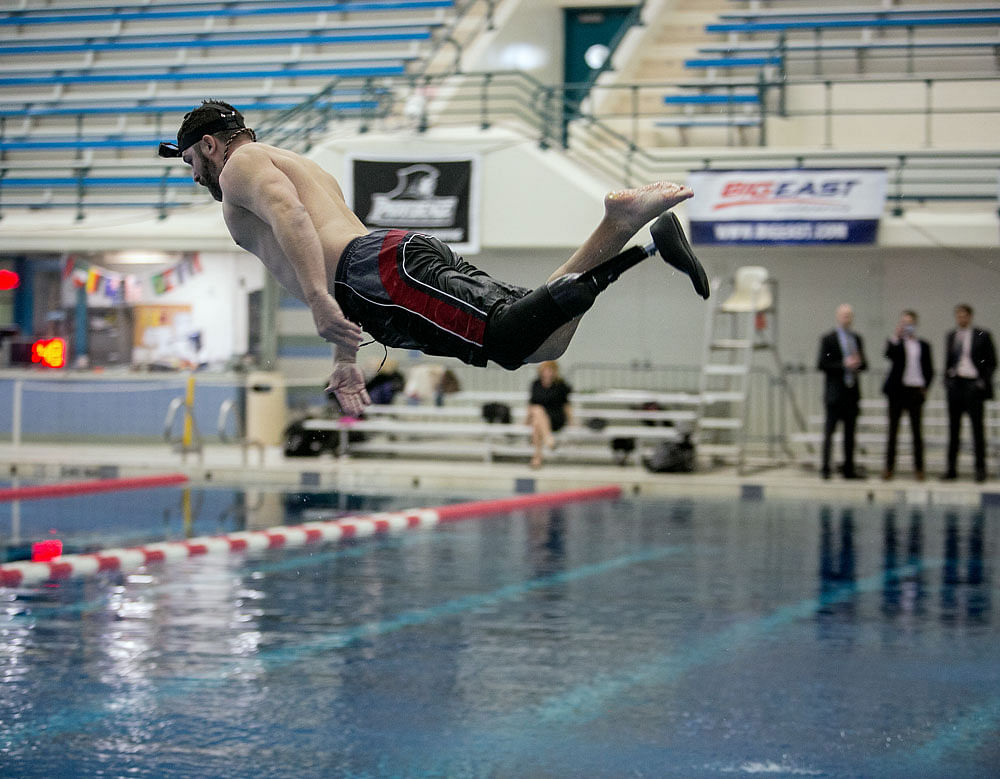 Leap of innovation: Dan Lasko tests out a new prosthetic leg designed to go from walking on land to swimming in water at the Nassau County Aquatic Centre in New York. The waterproof prototype that Lasko is testing stands to be the first fully functional swim leg. NYT