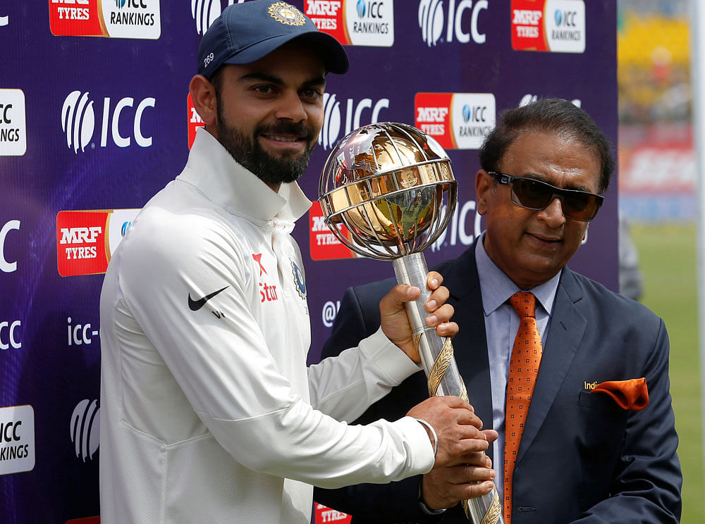 Virat Kohli receives the ICC Test Mace from former Indian cricket player Sunil Gavaskar (R) after India won the test series against Australia. REUTERS
