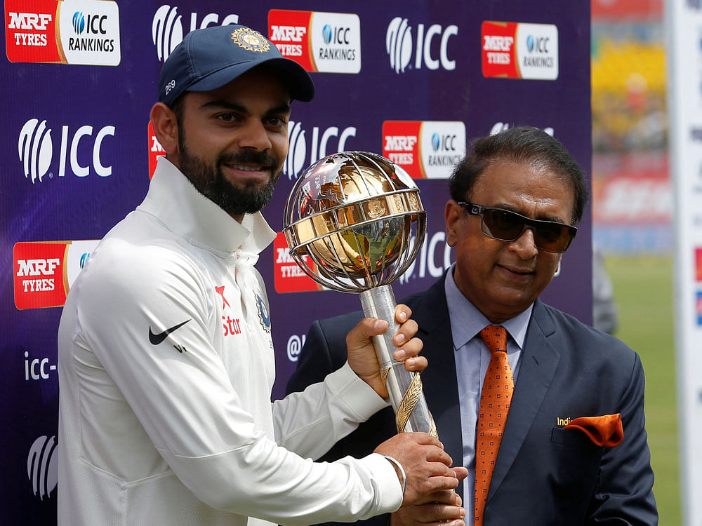 ndia's Virat Kohli receives the ICC Test Mace from former Indian cricket player Sunil Gavaskar (R) after India won the test series against Australia. REUTERS
