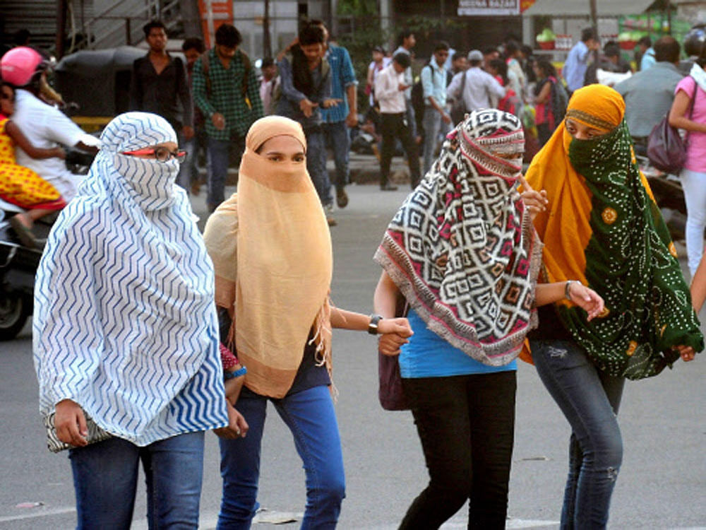 Girls cover their faces to get protection from scorching heat during a hot day in Nagpur, Maharashtra on Thursday. PTI Photo