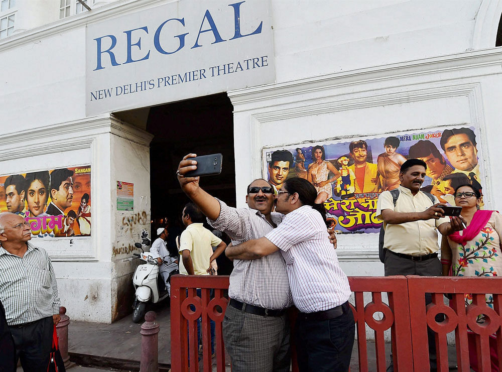 Movie buffs taking selfies in front of New Delhi's iconic theatre Regal Cinema which is going to close on Thursday with Raj Kapoor's 'Mera Naam Joker' and 'Sangam' to be the last movies to be shown. PTI Photo