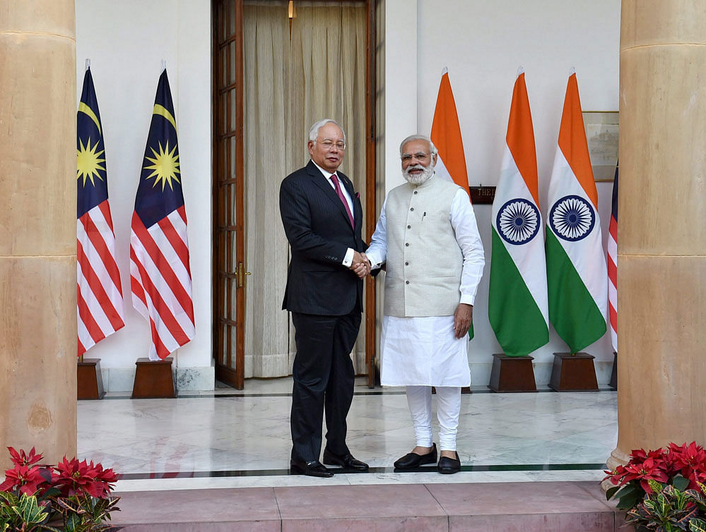Prime Minister Narendra Modi shakes hands with his Malaysian counterpart Najib Razak before their meeting at Hyderabad House in New Delhi on Saturday. PTI Photo