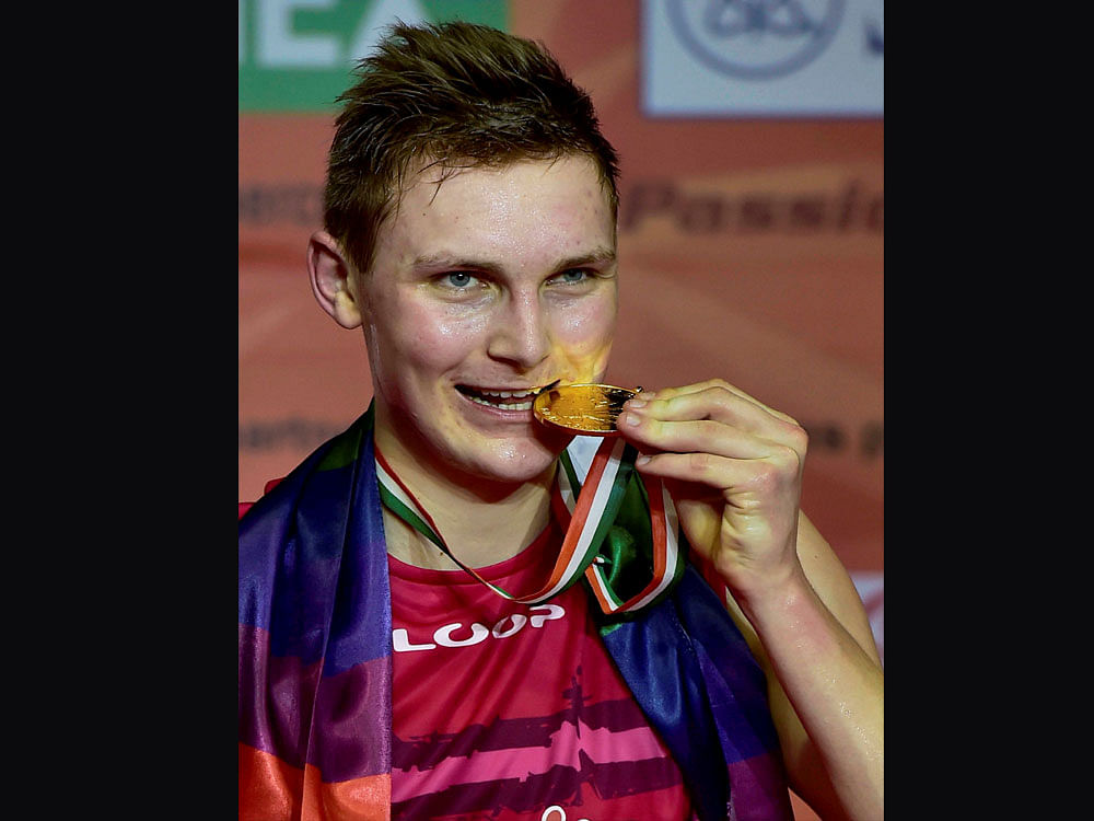 Denmark's Victor Axelsen bites his medal after winning men's single final at the Yonex-Sunrise India Open 2017 tournament in New Delhi on Sunday. PTI Photo