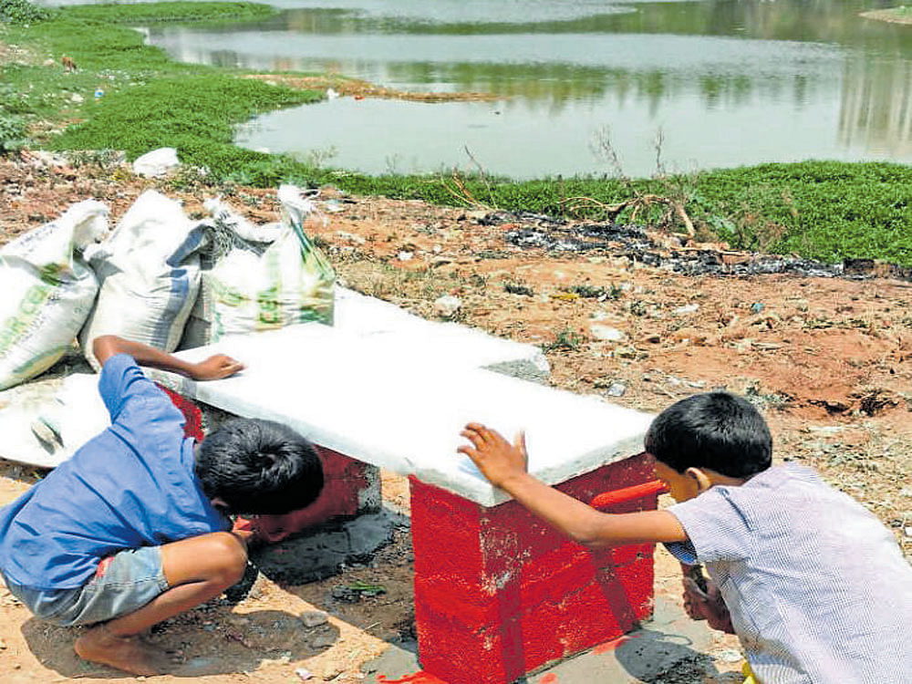 Volunteers put up a bench on the bank of Chunchaghatta lake in JP Nagar 7th Phase on Sunday. DH PV Photo