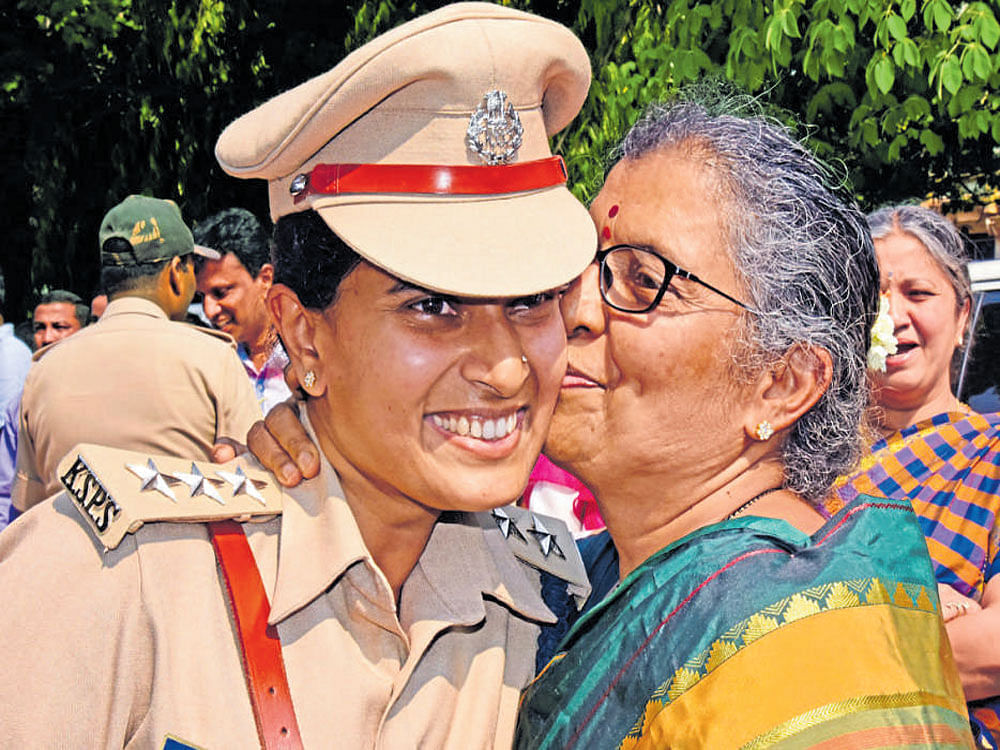 DySP S Jahnavi, who won the Chief Minister's Medal, gets a peck on the cheek from her mother at Police Flag Day on Sunday. dh photo