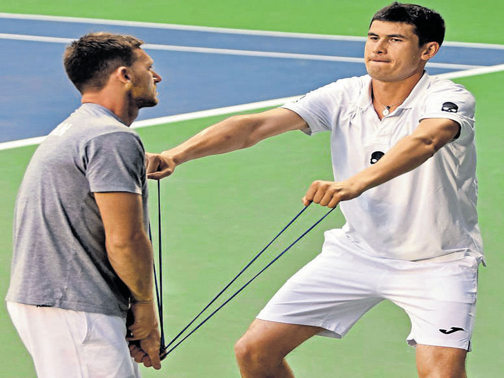 pull... Uzbekistan's Davis Cup veteran Farrukh Dustov (right) stretches during training on Tuesday. DH photo