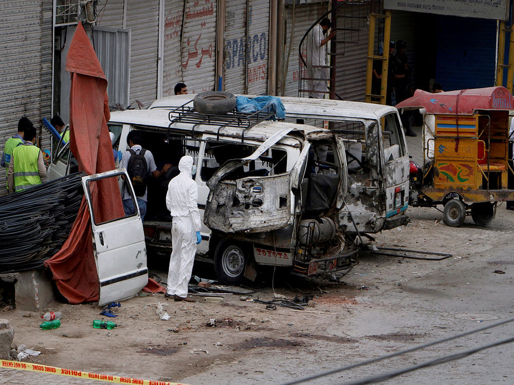 Pakistani investigators examine damage vehicles at the site of suicide bombing in Lahore, Pakistan, Wednesday, April 5, 2017. A suicide bomber detonated his explosives near a vehicle carrying census workers in eastern Pakistan on Wednesday, killing six people, two data collectors and four soldiers who were escorting them, a government spokesman and police said. AP/PTI
