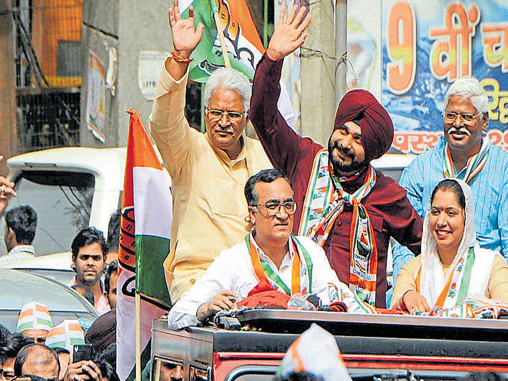 Punjab minister Navjot Singh Sidhu and Delhi Congress chief Ajay Maken during a roadshow for the MCD elections in  Rajouri Garden of New Delhi on Friday. PTI