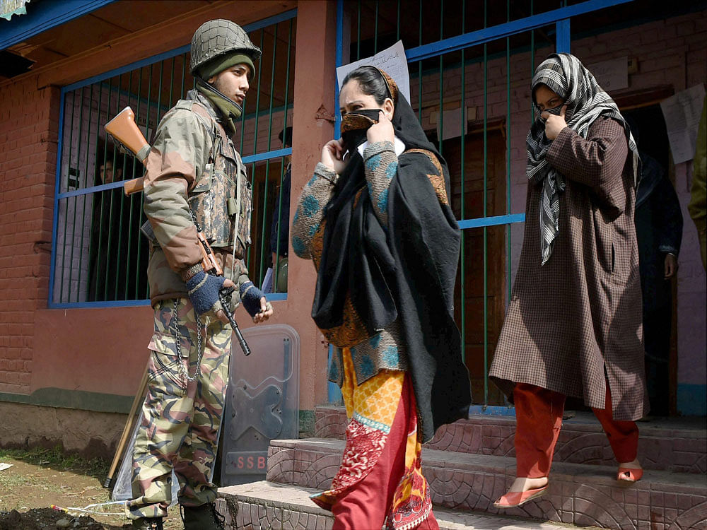 Women coming out from a polling station after casting their vote for Srinagar Parliamentary constituency of Jammu and Kashmir at Budgam in Srinagar on Sunday. PTI Photo