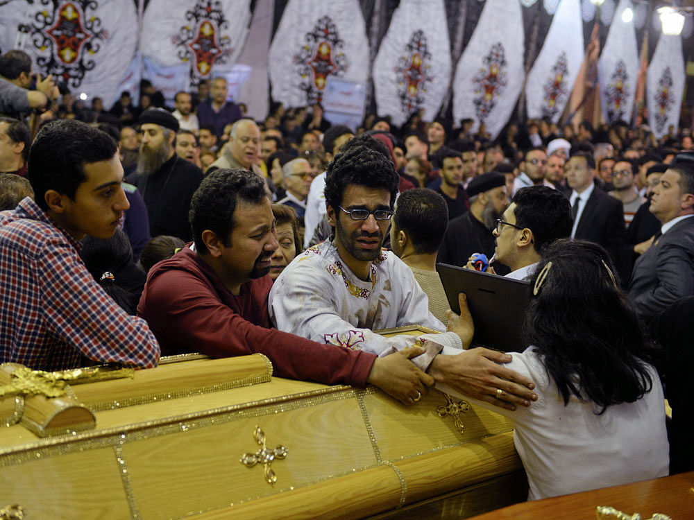 Relatives of victims react next to coffins arriving to the Coptic church that was bombed on Sunday in Tanta. Reuters photo