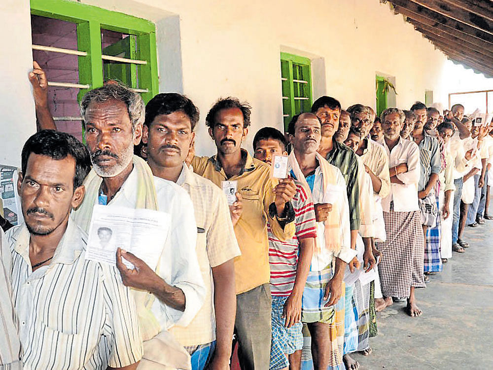 Voters queue up outside a polling booth at Maleyuru in Gundlupet taluk in Chamarajanagar district on Sunday. Gundlupet constituency registered 87.10% of polling.