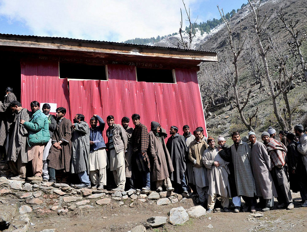 Voters in a long queue to cast their votes during Lok Sabha elections,at a polling booth in Srinagar on Sunday. PTI Photo