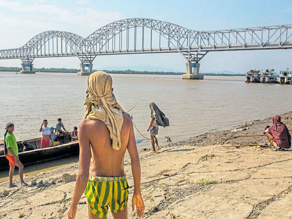 suppressing dissent: Labourers near a bridge that Aung San Suu Kyi's government chose to name after her father, who the locally dominant ethnic Mon group says steamrolled over their rights, in Mawlamyine. NYT