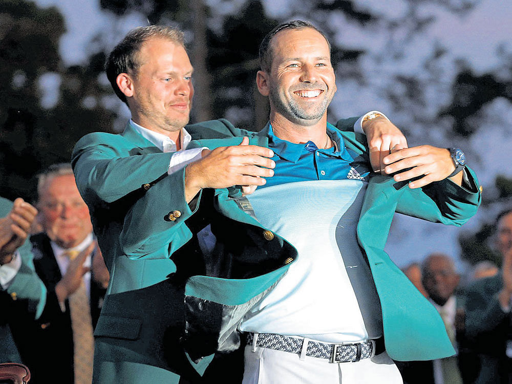 It fits!: Spaniard Sergio Garcia is presented the Green Jacket by last year's champion Danny Willett after winning the US Masters at Augusta on Sunday. reuters