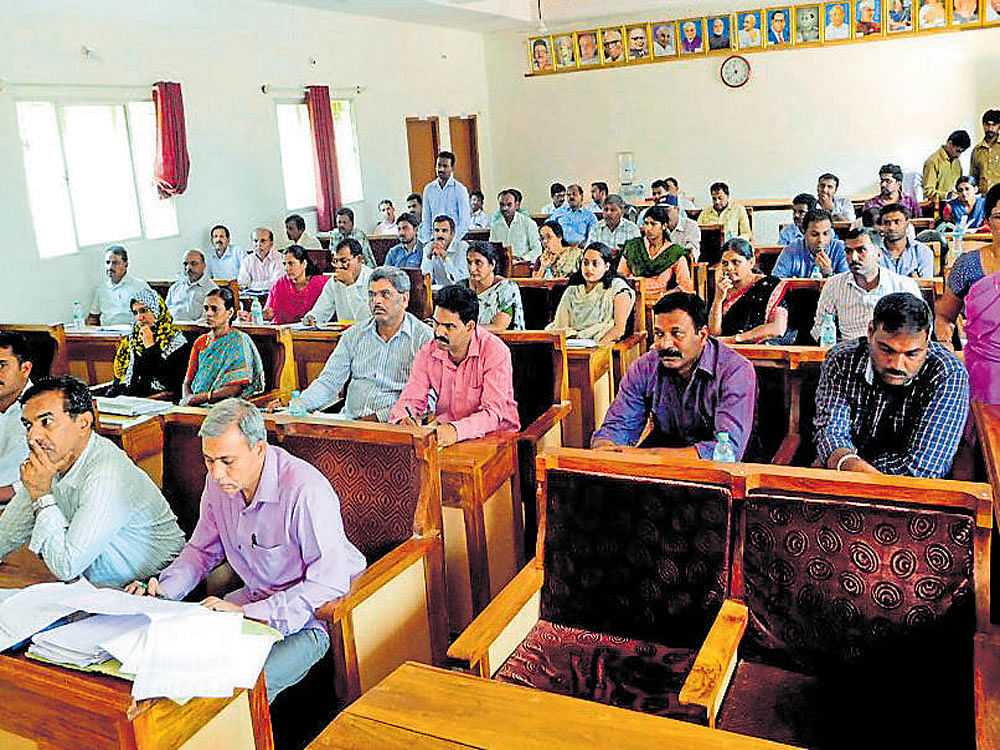 Officials take part in the review meeting at the Taluk Panchayat Hall in Mudigere on Tuesday. DH photo