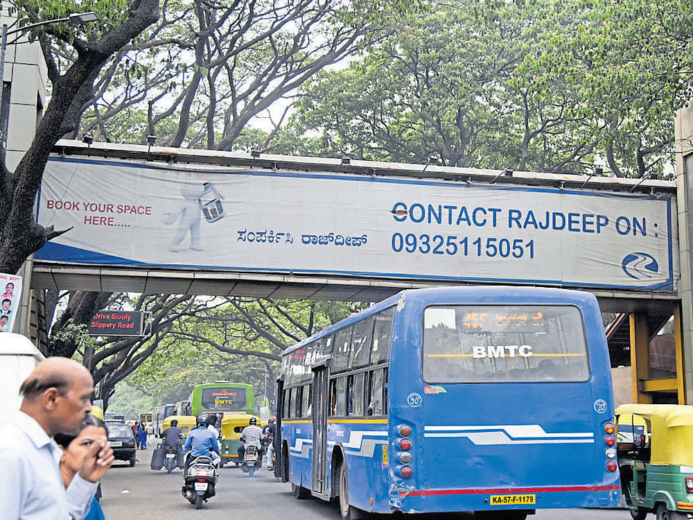 The skywalk at Kandaya Bhavan on KG Road is an example of shoddy planning. It has encroached on the footpath, forcing people to walk on the road. It has also been covered by advertisement boards on either side, which makes it easy for miscreants to target women. DH photo