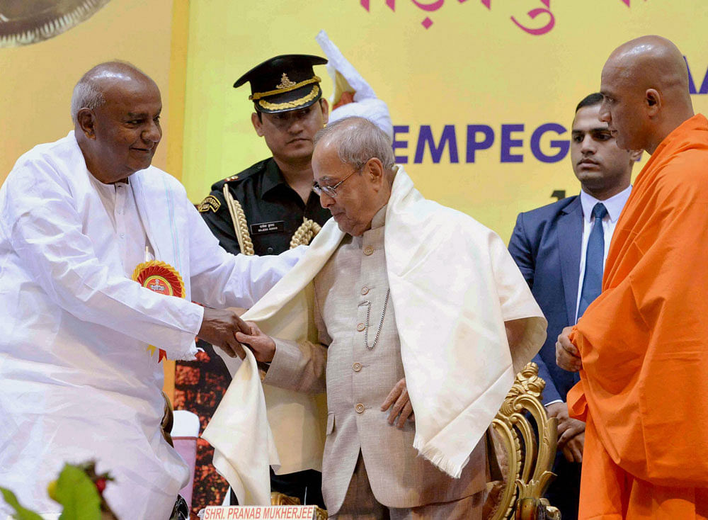 President Pranab Mukherjee being offered a shawl by former PM Deve Gowda at the inauguration of the Kempe Gowda festival at Talkatora Indoor Stadium on Saturday. PTI Photo
