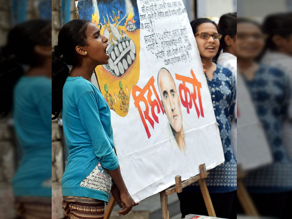 Two girls display a painting of former Indian naval officer Kulbhushan Jadhav in Mumbai on Saturday. PTI