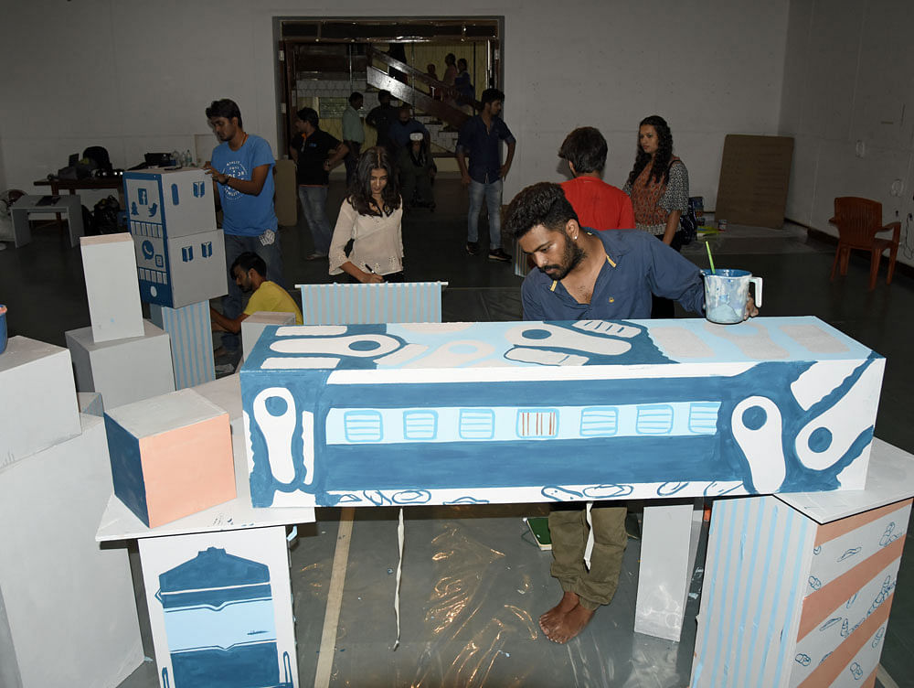 Artists create their artworks for the 'Art in Transit' project at the Venkatappa Art Gallery in the city on Sunday. DH PHOTO