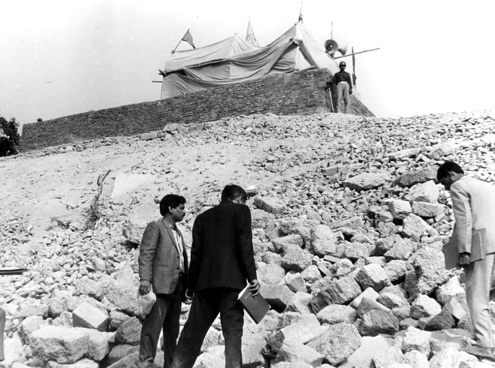 A team of CBI men surveying the debris of the demolished structure which was demolished by Karsevaks on Dec 6th. on the top of mound in the background is the new Ram temple with a sentry gaurding [DH/PV Archives]