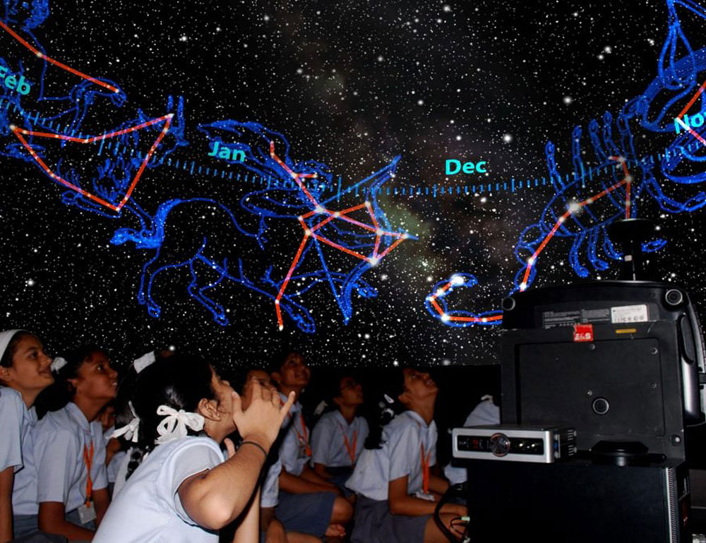High school children watching the night sky in mobile planetarium. An inflatable dome which serves as a planetarium.