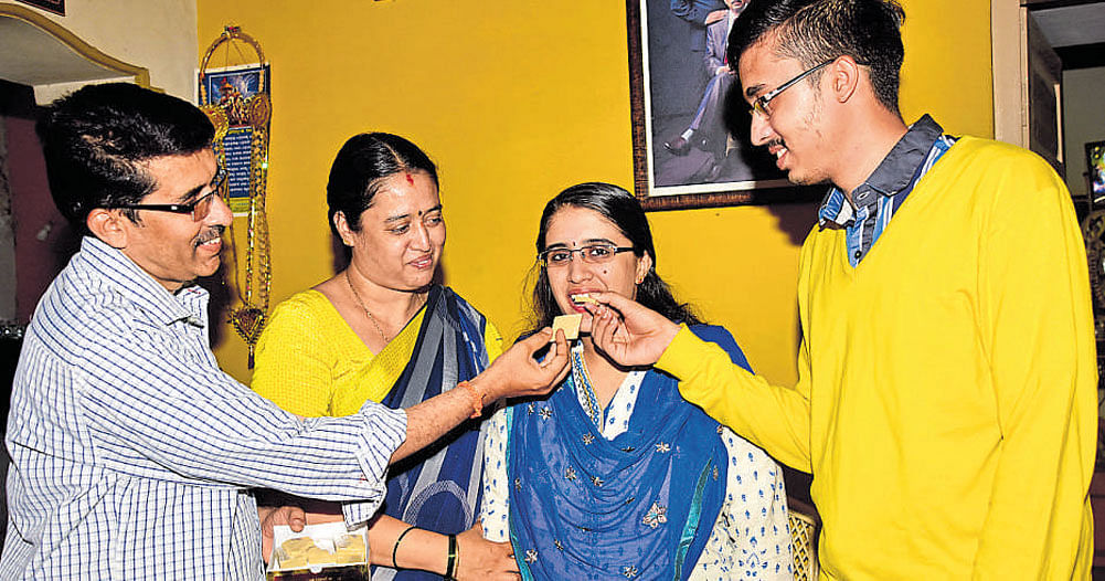 KPSC topper R Aishwarya (second from right) celebrates with her father R Ramaradya, mother Vani and brother Adithya Ramaradya at her house in Mysuru on Sunday. DH Photo