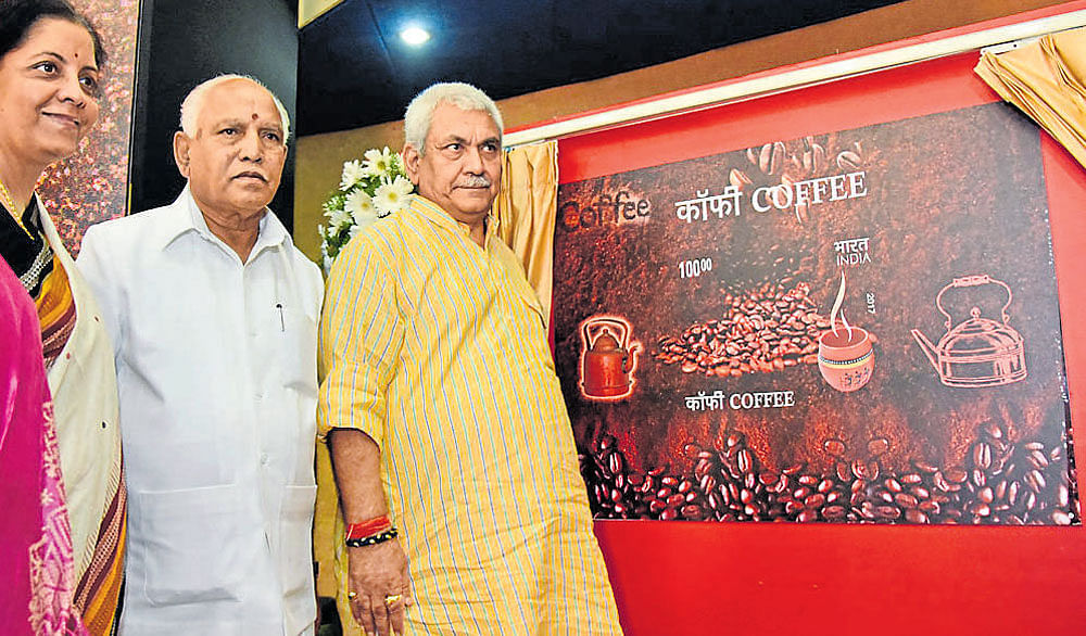 Union Minister of State for Communication Manoj Sinha unveils a commemorative  coffee-scented postage stamp at the Bengaluru General Post Office on Sunday. Former  chief minister B&#8200;S&#8200;Yeddyurappa and Union Minister of State for Commerce and Industry  Nirmala Sitharaman are seen.  dh photo