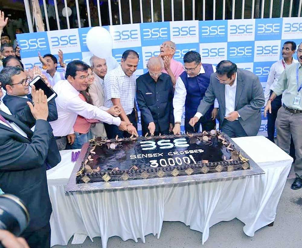 A cake weighing 30 kg is cut as part of celebrations outside BSE as the Sensex closed above the 30k mark on Wednesday. DH photo