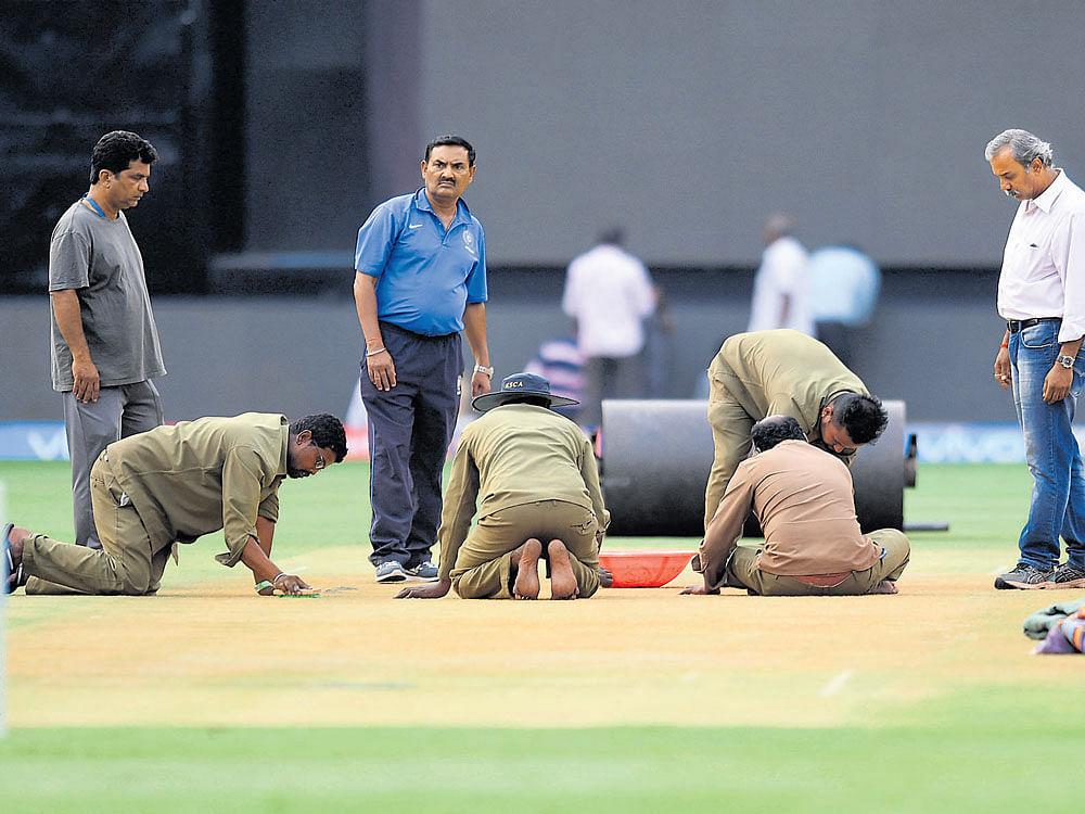 Following incessant rain on Tuesday, the ground staff at the Chinnaswamy stadium are leaving no stone unturned in getting the pitch ready for Thursday's match. DH Photo/Kishor Kumar Bolar