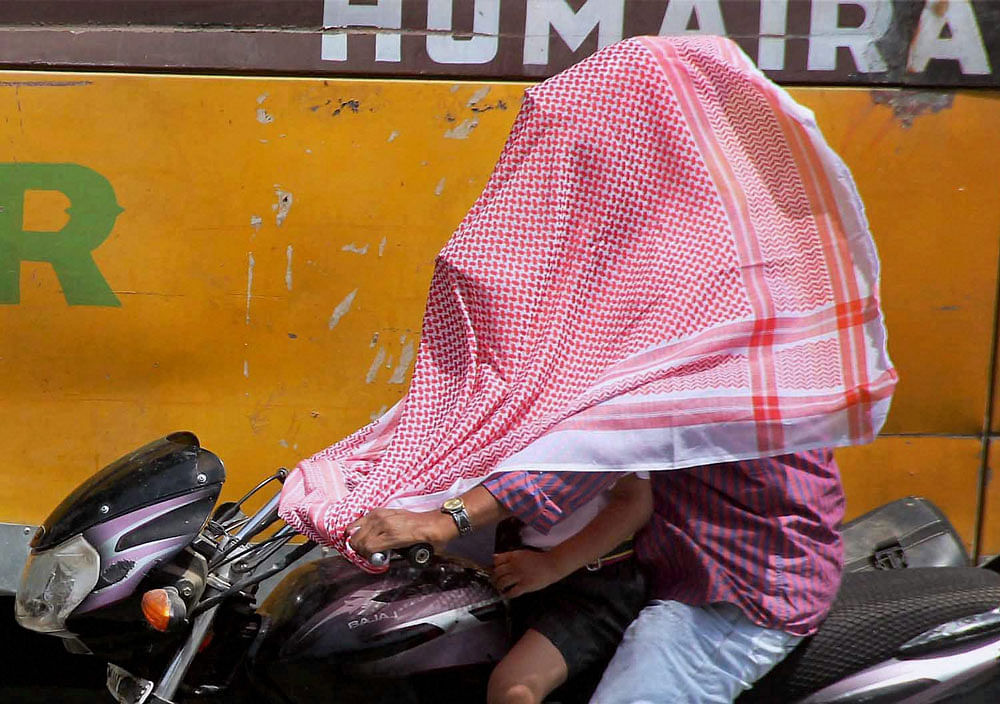 People cover their faces to protect themselves from scorching heat in Allahabad. PTI photo