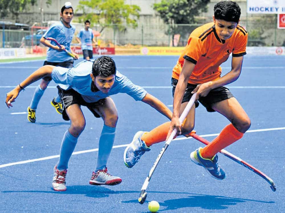 Intense Tarun NT (right) of Hockey Coorg and Ravi Kumar of Hockey Himachal vie for the ball on Friday. DH PHOTO