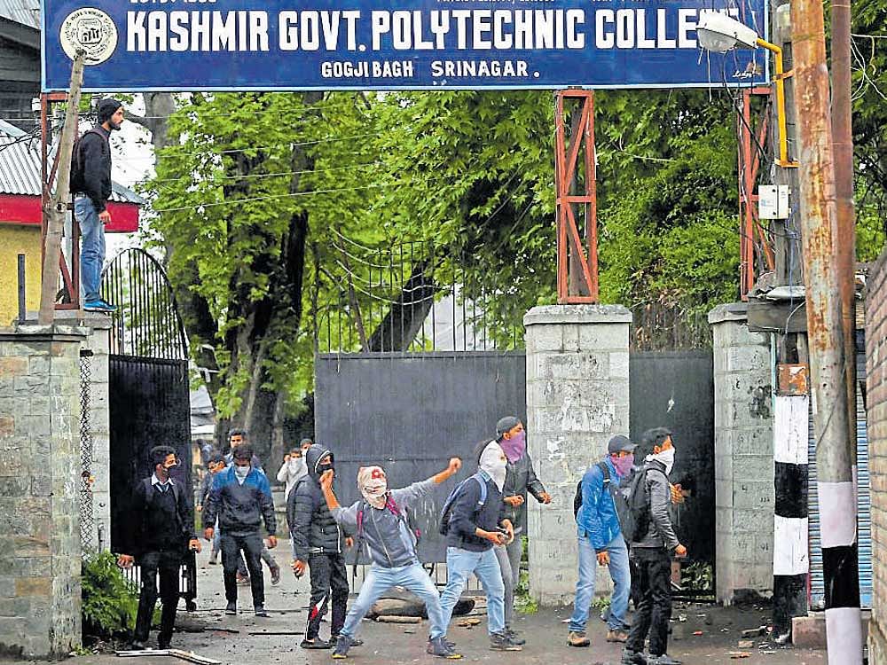 Students throw stones at the police during a protest in Srinagar on Saturday. PTI