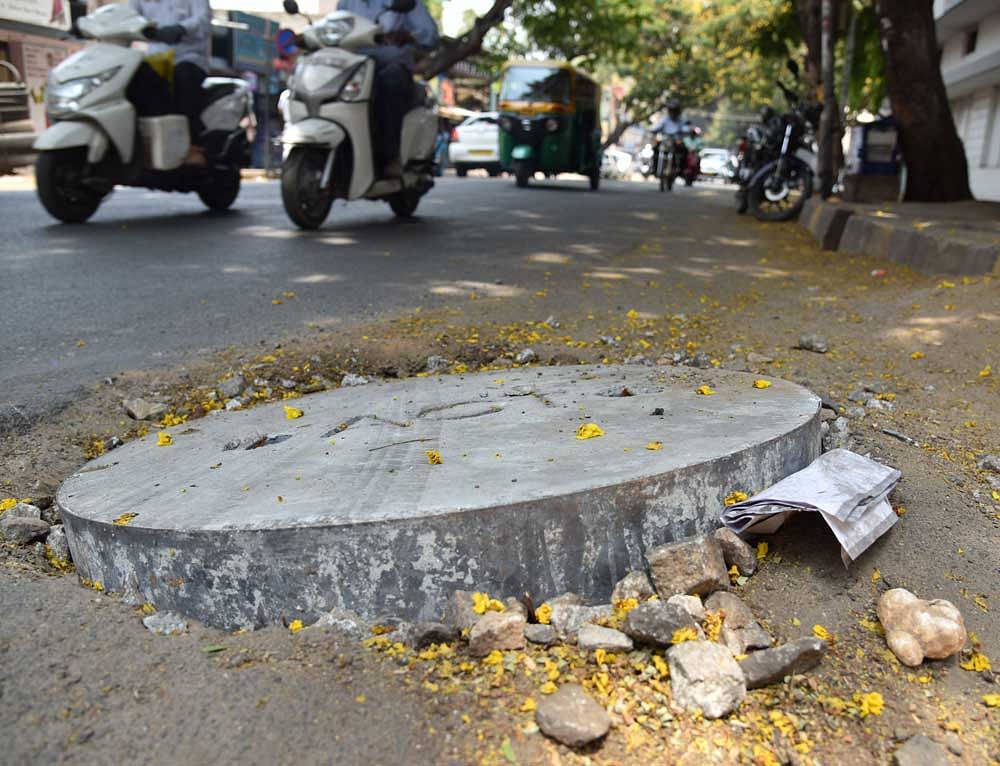 Risky: Protruding manhole lids, like in Ashwath Nagar, pose a danger to motorists.  DH PHOTOS BY B K JANARDHAN