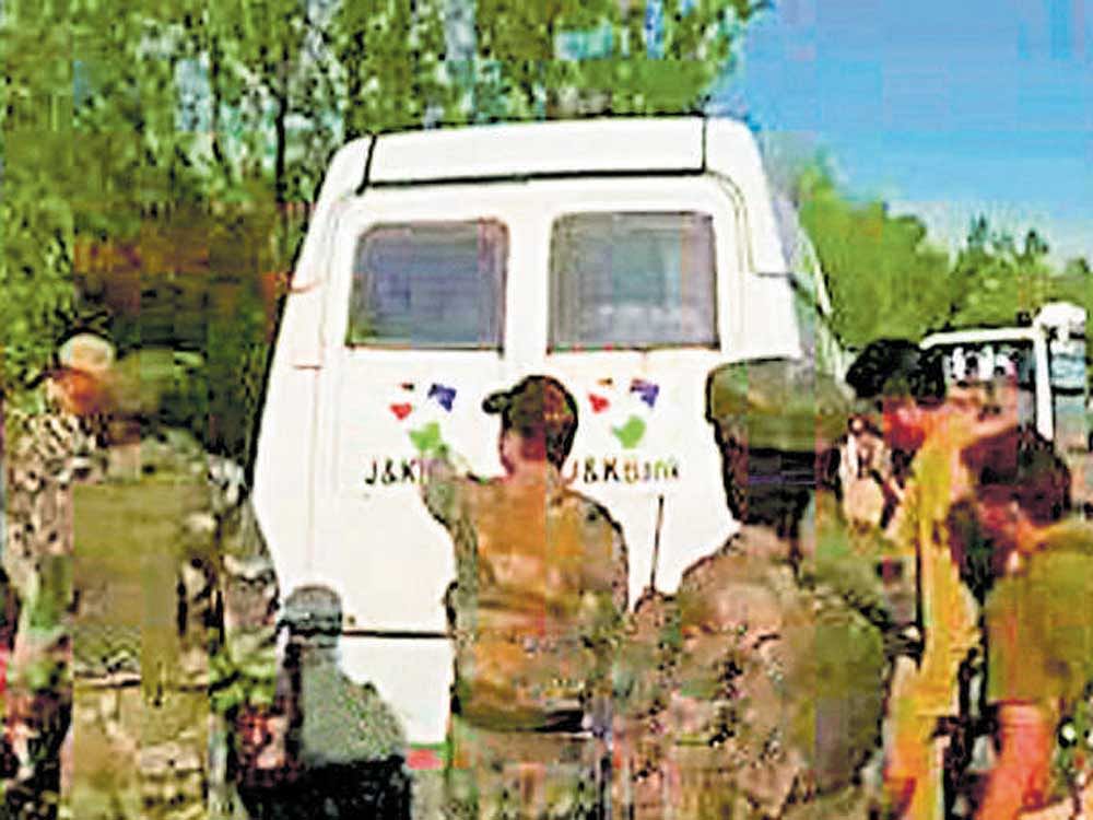 Security personnel inspect the site where suspected  militants looted the cash van of a government-run bank in  Kulgam, Jammu & Kashmir on Monday. PTI