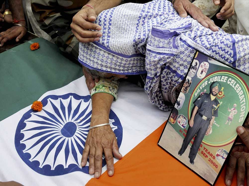 The soldier's wife Paramjit Kaur was later allowed to take a last look. She was shocked to see the mutilated, headless body of her husband in the coffin. PTI Photo
