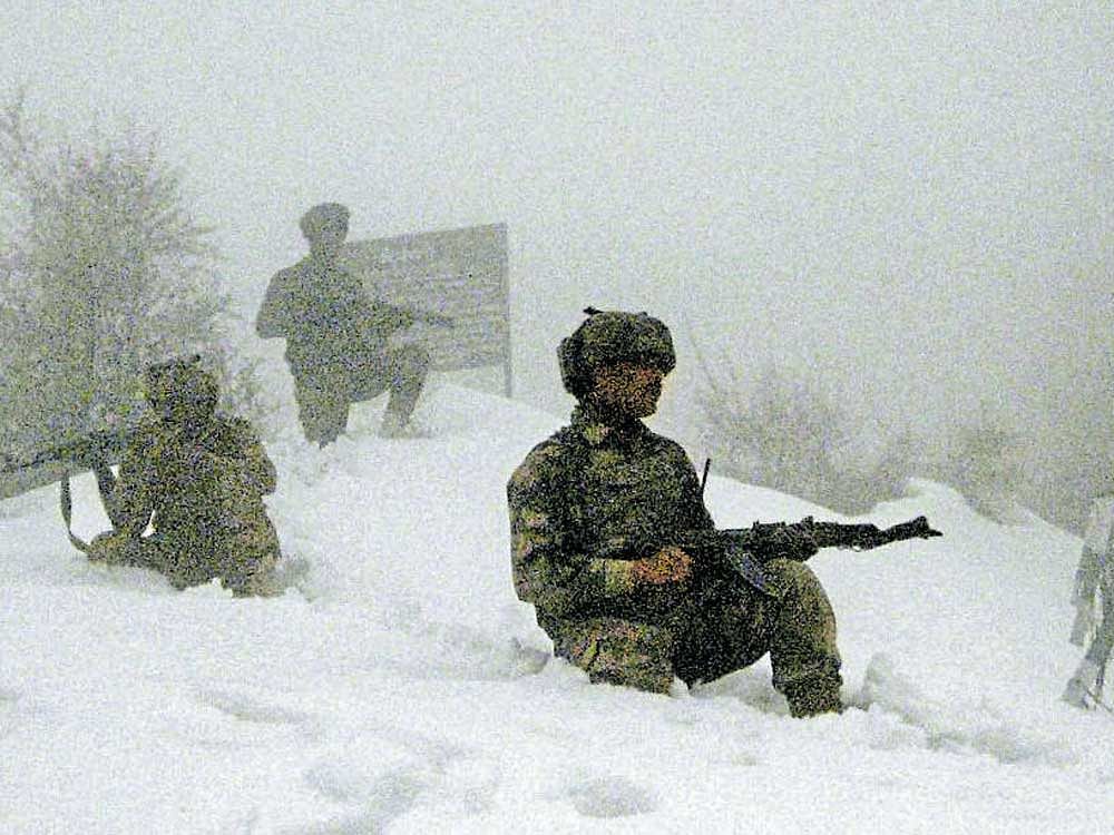 Army jawans keep vigil amid heavy snowfall in Poonch district of Jammu and Kashmir on Tuesday. PTI