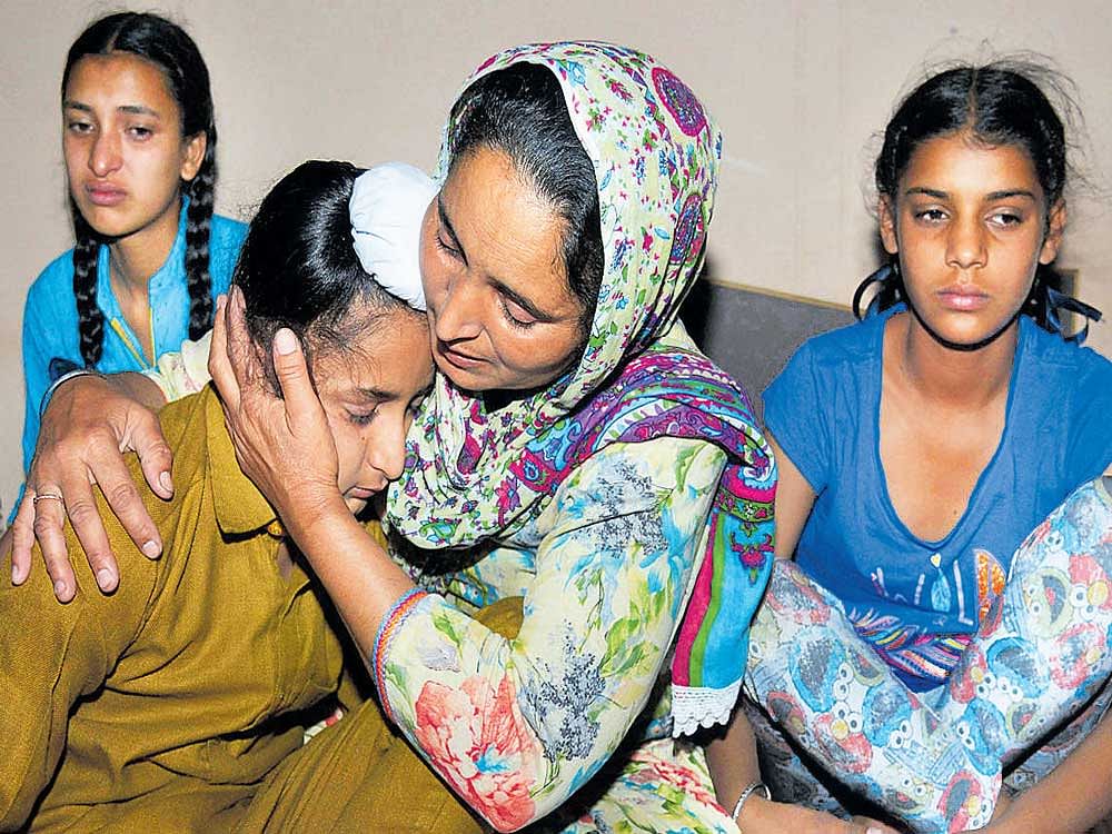 IN&#8200;GRIEF: Paramjeet Singh's widow Paramjit Kaur (centre) comforts her son Sahildeep Singh (left) as she is flanked by her daughters Simrandeep Kaur (rear left) and Khushdeep Kaur at their residence in Vein Poin village near Amritsar on Tuesday. AFP